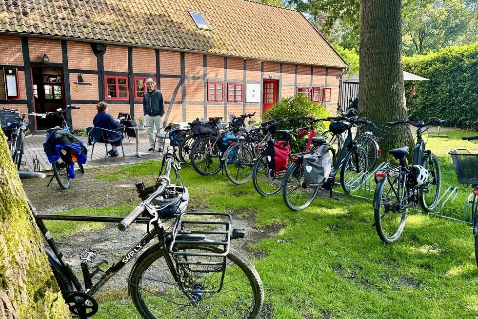 20 geparkte Fahrräder stehen kreuz und quer vor einem Fachwerkhaus.