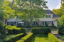 Ein altes Landhaus mit einem großen Garten mit ordentlichen Buchsbaumhecken