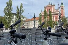 Im Vordergrund sieht man die Lenker von abgestellten Fahrrädern, im Hintergrund das Rathaus von Ljubljana