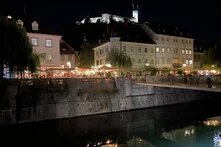 Beleuchtete Uferpromenade am Fluss Ljubljanica bei Nacht