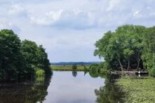 Blick auf den Fluss "Hamme" bei Worpswede, am Ufer sieht man einen Biergarten.