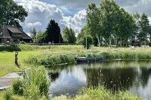 Blick auf einen ehemaligen Torfhafen am Fluss Hamme, mit einem Holzsteg und einem kleinen Boot