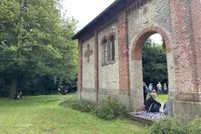 Eine Fahrrad-Reisegruppe macht Pause an der Ruine eines alten Backstein-Gebäudes (sogenannte Wasserhorst) im Bremer Blockland