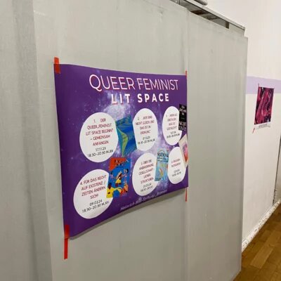 Foto von einem Plakat mit Weltraum-Muster, auf dem steht "Queer Feminist Lit Space" und darunter in Kreisen die Themen der einzelnen Sitzungen