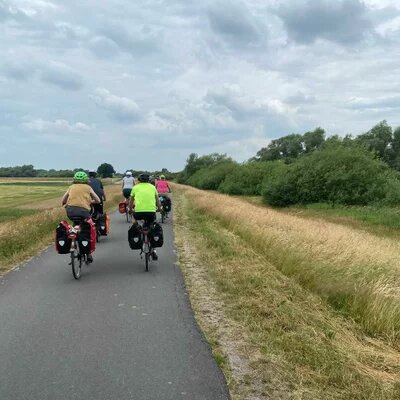 Die Reisegruppe mit dem Fahrrad auf einem Feldweg auf dem Wümmedeich